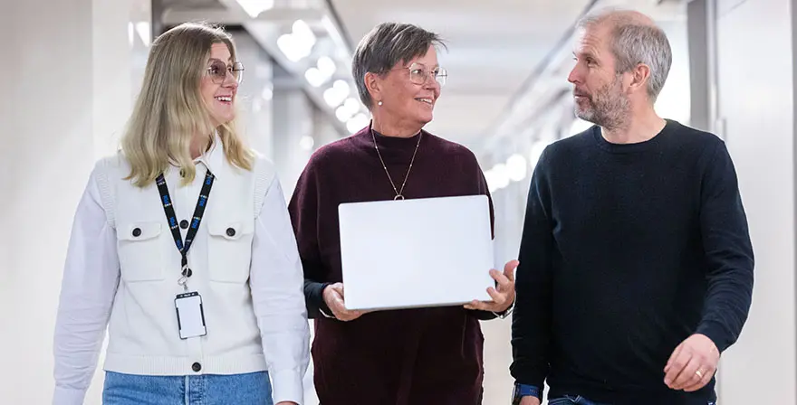 Tre personer som går och pratar