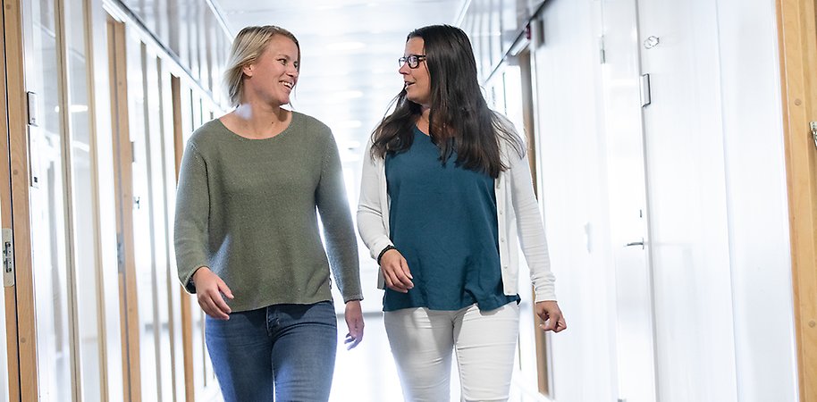 Two persons walking in a corridor